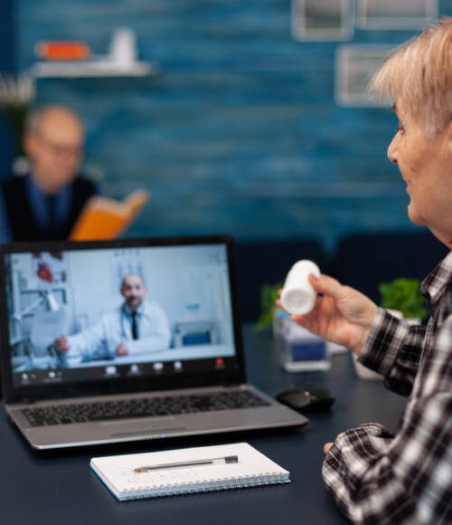 Senior woman showing pills bottle a elder patient using telehealth service talking to an online doctor